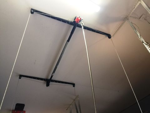 1994 Ford Bronco - A garage door opener mechanism is mounted to the ceiling, with cables extending downwards.