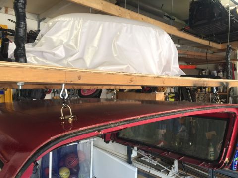 1994 Ford Bronco - The interior of a red vehicle is visible, with a tarped object stored above it.