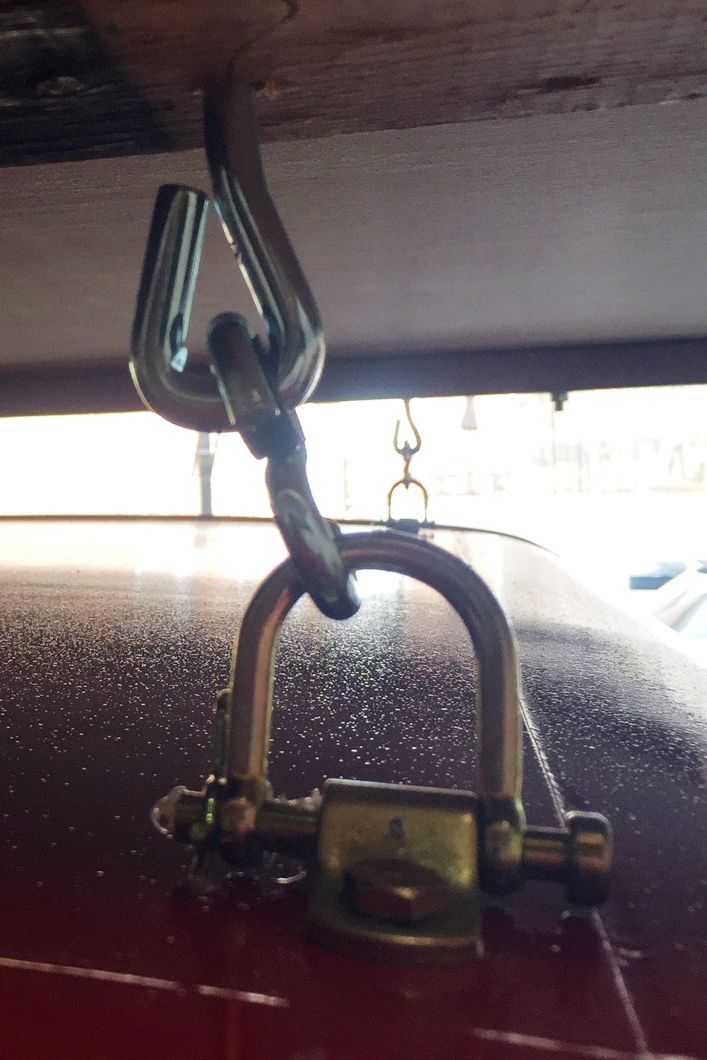 Metal hook and chain assembly on red vehicle roof