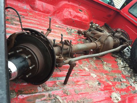 1967 Ford Custom Wagon - A disassembled rear axle assembly is shown in the bed of a red truck, indicating it is a spare part.