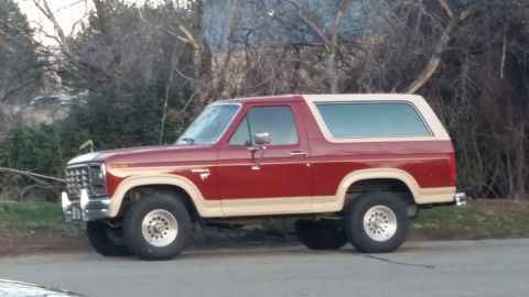 1985 Ford Bronco - Side view of a two-tone red and tan 1985 Ford Bronco.
