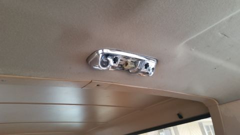1985 Ford Bronco - A chrome interior dome light fixture is mounted to the tan headliner of a vehicle. The fixture has two clear lenses and appears to be missi…