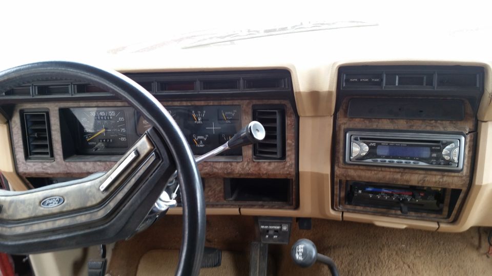 Ford truck tan dashboard with gauge cluster, steering wheel and aftermarket JVC stereo