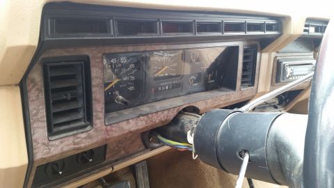 1985 Ford Bronco - The interior of a vintage Ford truck or SUV shows the dashboard with gauges, air vents, and a radio. The steering column is visible with wi…