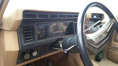 1985 Ford Bronco - The interior of a vintage Ford Bronco shows the dashboard with gauges, steering wheel, and a floor shifter. The tan and black interior appe…