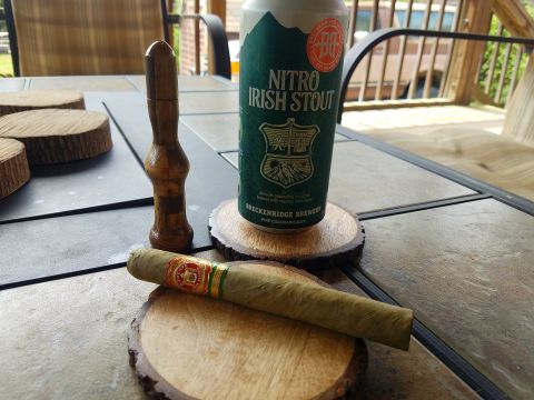 2018 Ford Bronco - A cigar rests on a wooden coaster next to a can of Breckenridge Brewery Nitro Irish Stout and a wooden cigar holder on a tiled outdoor tabl…