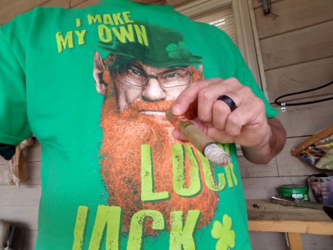 2018 Ford Bronco - A person wearing a green t-shirt with a leprechaun graphic and the text "I MAKE MY OWN LUCKY JACK" is holding a cigar. The background shows…
