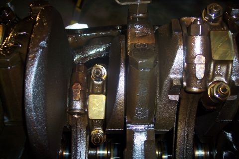 1995 Ford Bronco - This is a close-up view of the internal components of an engine, likely a crankshaft and connecting rods, coated in oil. Several bolts and…