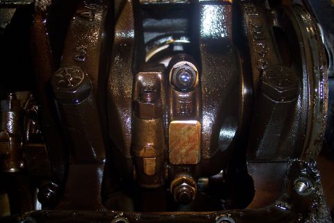 1995 Ford Bronco - This is a close-up view of the internal components of an engine, likely a crankshaft assembly, covered in dark oil. Visible are bolts, nuts…