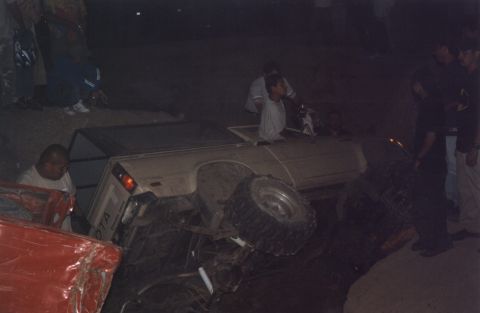 2000 Ford F-450 - A Toyota pickup truck has overturned, with several people observing the scene.