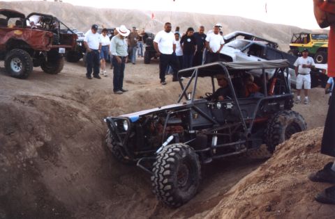2000 Ford F-450 - Several off-road vehicles and spectators gather in a desert landscape.