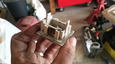 1985 Ford Bronco - A hand holds a disassembled beige plastic interior trim piece with visible dirt and grime. The background shows a cluttered garage setting…