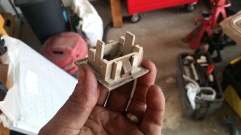1985 Ford Bronco - A person's hand holds a beige plastic automotive part with metal clips inside a garage. The part appears to be a switch or button housing.