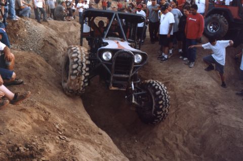2000 Ford F-450 - A custom off-road buggy navigates a steep dirt incline as onlookers watch.