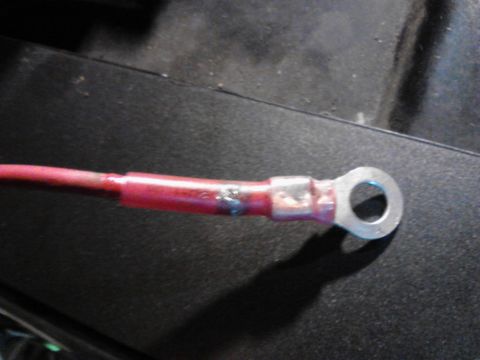 1995 Ford Bronco - A close-up shot shows a red insulated wire with a silver ring terminal attached. The terminal is crimped onto the wire, and the insulation…