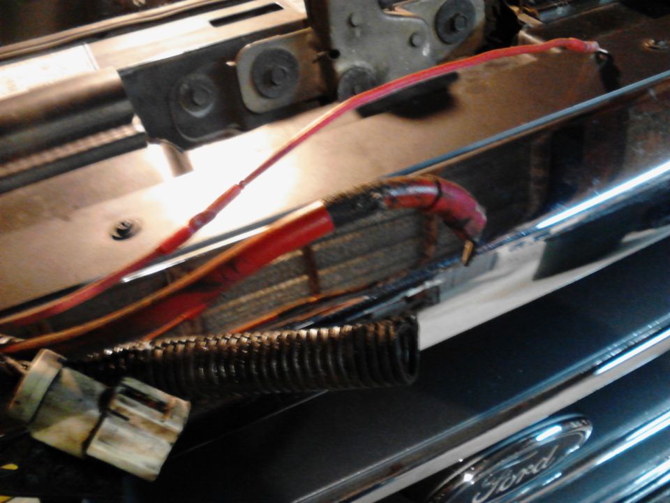 Close-up of red wiring and electrical connector in vehicle engine bay.