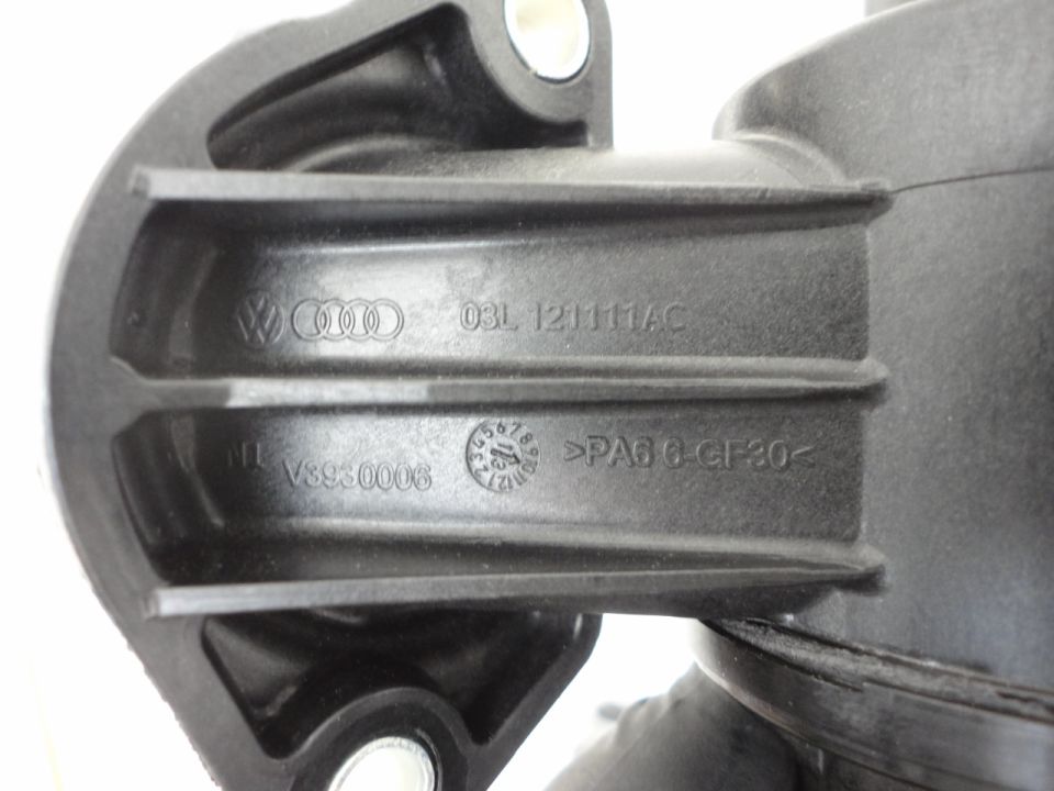 Black plastic automotive part with embossed text and logos: VW, Audi, 03L 121111AC, NL V3930006, >PA6 6-GF30<