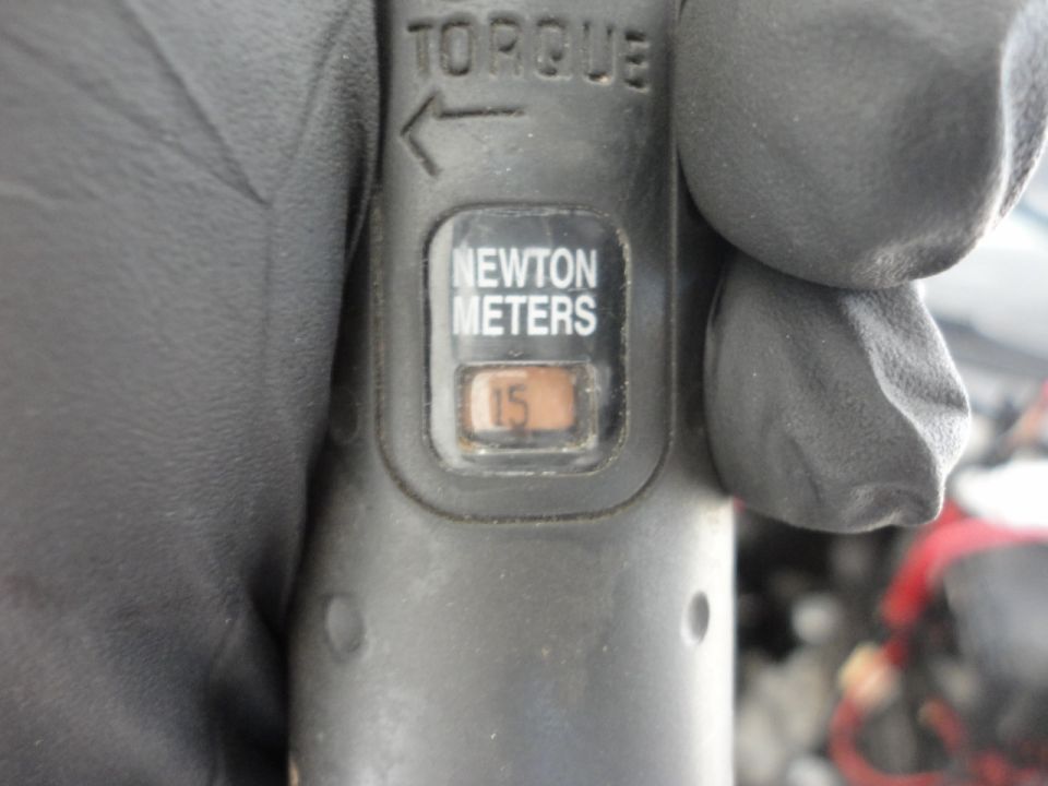 Close-up of a torque wrench showing 15 Newton Meters setting.