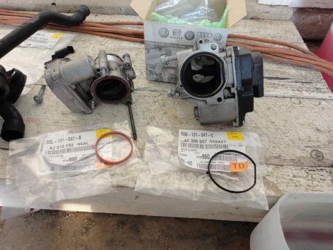 2010 Volkswagen Jetta - Throttle body and replacement gaskets are laid out, with part numbers clearly visible on the packaging.