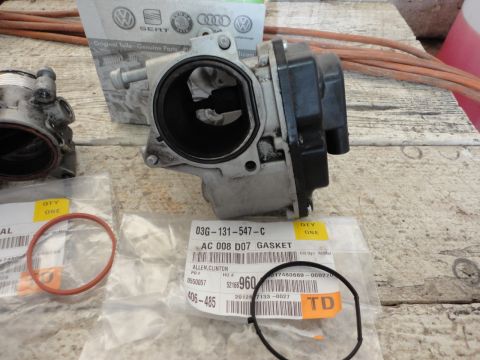 2010 Volkswagen Jetta - New throttle body and gaskets laid out on a wooden surface, ready for installation.