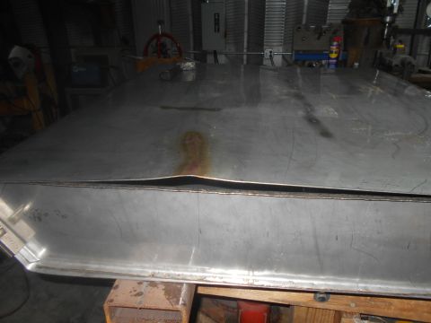 1992 Ford Bronco - A large, dented, and scratched sheet metal panel with a rust stain is shown in a workshop setting. The panel appears to be part of a larger…