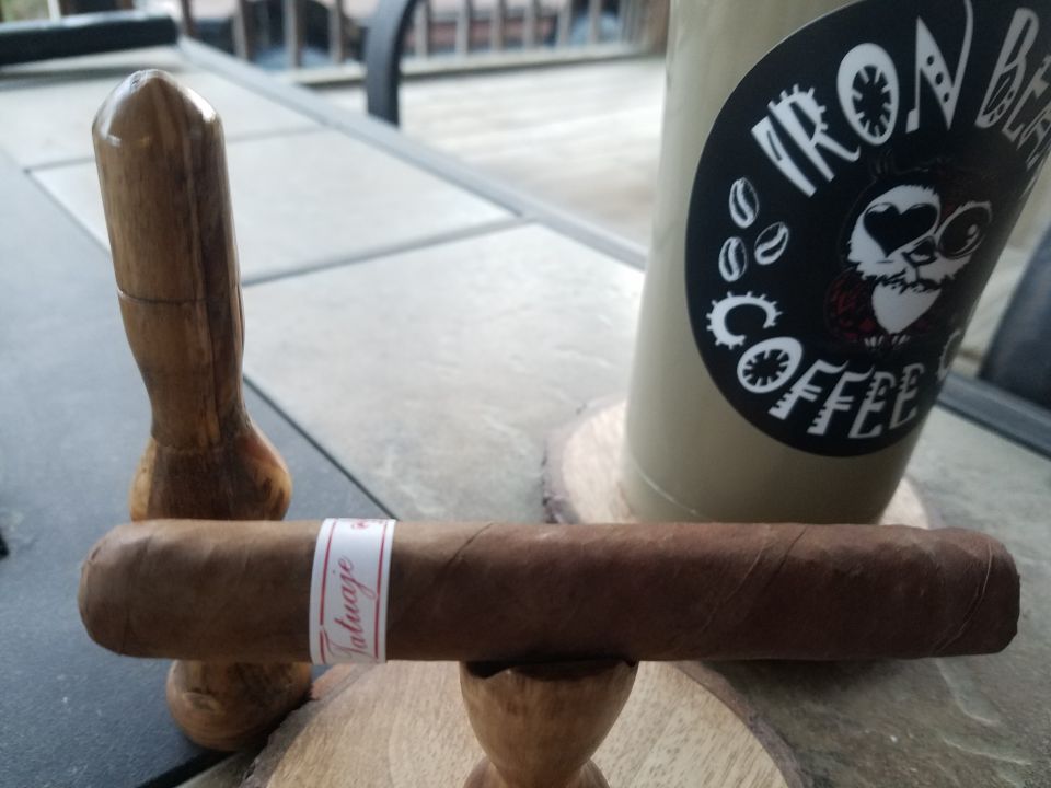 A cigar with a "Tatuaje" band and a "Iron Bear Coffee" cup.