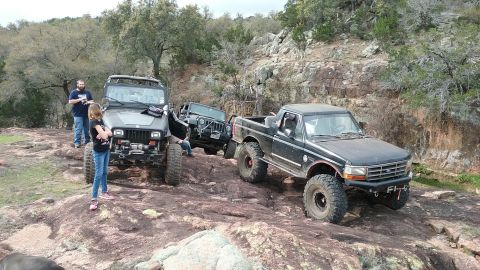 1995 Ford Bronco - A 1995 Ford F-150 pickup truck navigates a rocky off-road trail alongside other vehicles.