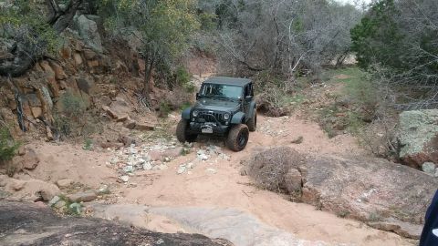 1995 Ford Bronco - A Jeep Wrangler tackles a challenging, rocky terrain on an off-road adventure.