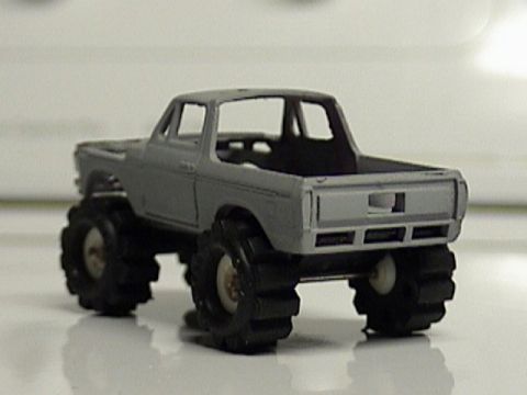 1979 Ford Bronco - Rear view of a gray toy truck with large tires, showing "SUPERMOTORS" logo.