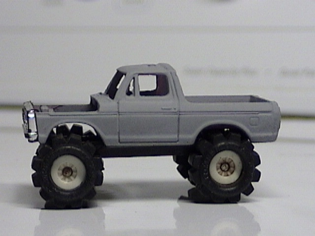 Gray 1979 Ford Bronco with monster truck tires, side view
