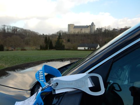 2010 Audi A4 - A castle sits on a hill behind a car with a blue tow strap and a bottle opener keychain attached.