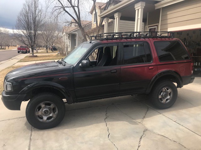 2000 Ford Explorer SUV, two-tone paint, roof rack, parked in driveway