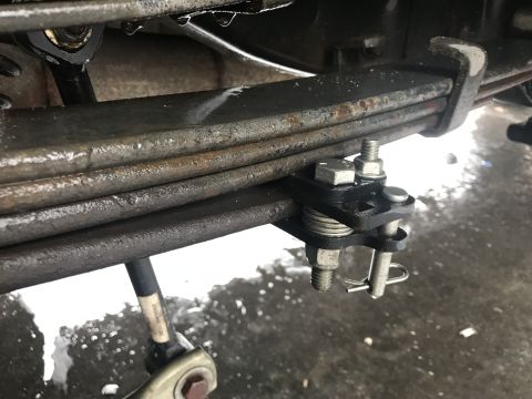 1997 Dodge 3500 - Close-up of a vehicle's leaf spring assembly, with visible rust and water.