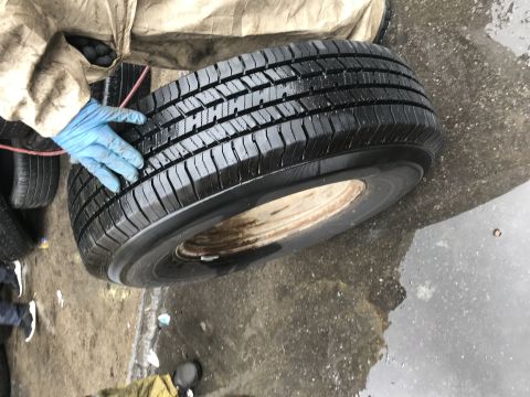 1997 Dodge 3500 - A person is inspecting a tire and wheel, possibly for replacement or repair.