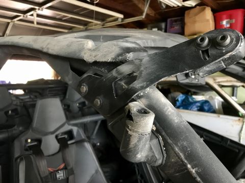 1988 Ford Bronco - Close-up view of the damaged roll cage and interior of an off-road vehicle.