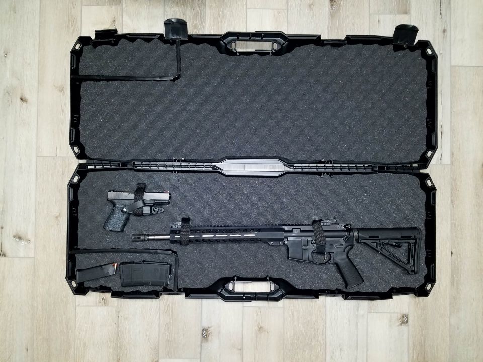 Black rifle and handgun in a foam-lined case with magazines