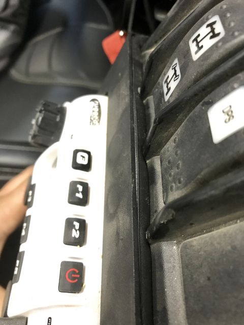 1988 Ford Bronco - Close-up of a vehicle's interior, showing a white control panel and a black shifter with four-wheel drive indicators.
