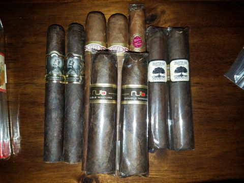 2018 Ford Bronco - A collection of cigars, including NUB Double Maduro and Charter Oak brands, laid out on a wooden table.