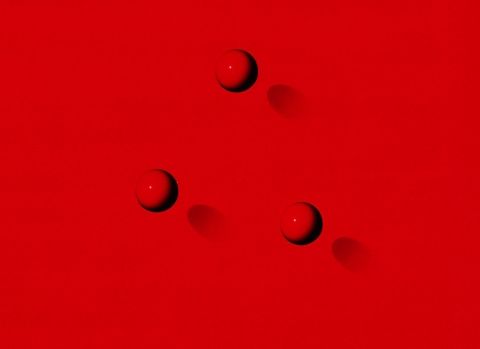 1967 Ford Custom Wagon - A close-up view of three red spheres with distinct shadows on a solid red background.