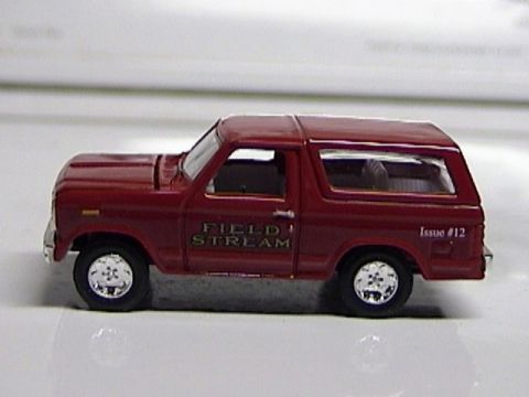 1979 Ford Bronco - A small red toy SUV with text on its side is viewed from the left.