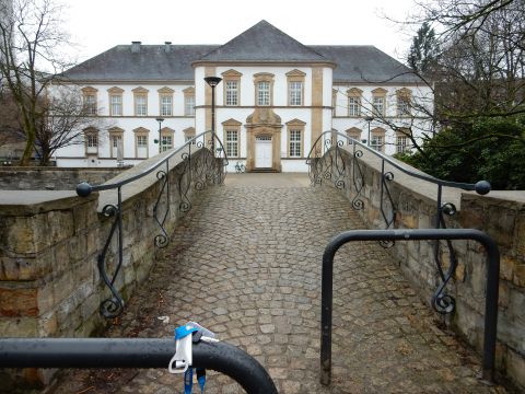 2010 Audi A4 - A cobblestone bridge crosses a small body of water, leading to an ornate building with a symmetrical facade.