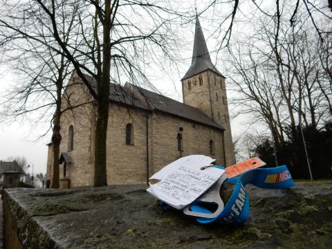 2010 Audi A4 - A stone church stands under a cloudy sky, with notes and a NASCAR lanyard resting on a mossy wall.