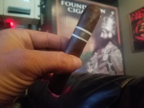 2018 Ford Bronco - Hand holding a cigar with an album cover in the background.