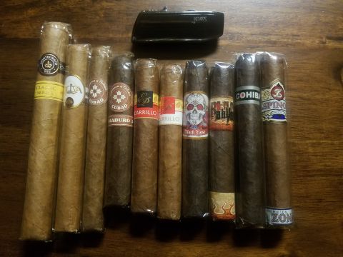 2018 Ford Bronco - A collection of cigars with various bands and a lighter are laid out on a wooden table.