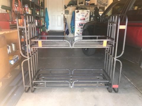 2000 Ford Explorer - Metal camping bunk beds are stored in a garage, with a black SUV parked behind them.