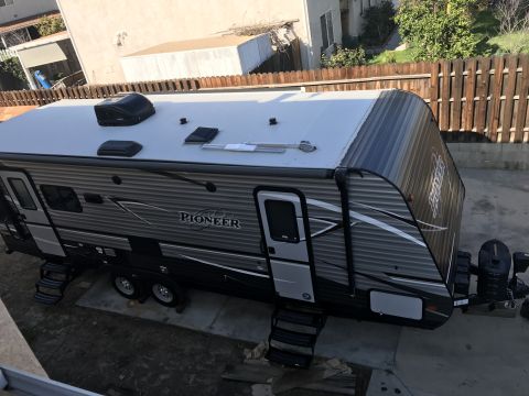 2018 Yugo GV - A travel trailer is parked in a residential driveway, showing its side profile and roof details.