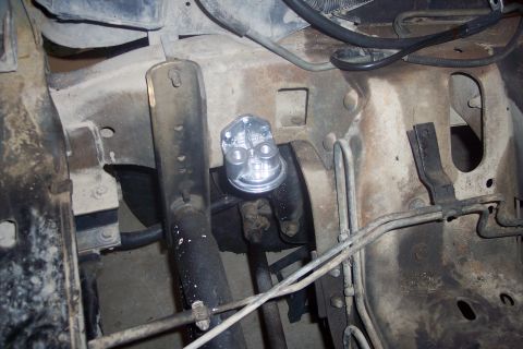 1995 Ford Bronco - A close-up view of a fuel filter assembly, showing its mounting and surrounding engine bay components.