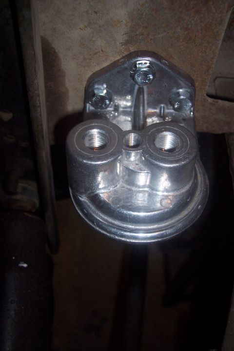 1995 Ford Bronco - Close-up view of a metal fuel filter housing, likely from a vehicle's engine bay.