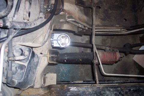 1995 Ford Bronco - This image shows a close-up view of a vehicle's steering rack and pinion assembly, including a sensor and protective boot.