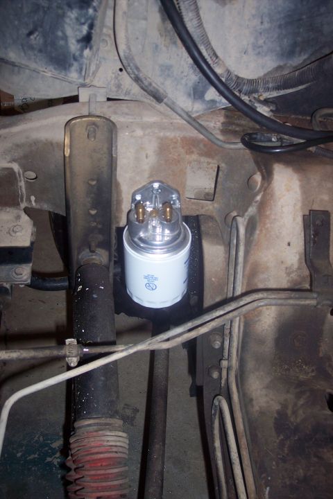 1995 Ford Bronco - Close-up view of an oil filter and suspension components within a vehicle's engine bay.
